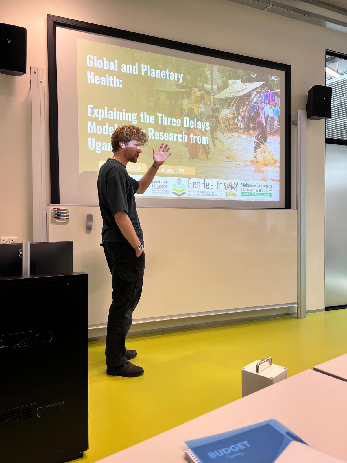 Speaker giving an invited guest lecture at Utrecht University on global and planetary health with the Three Delays Model on the screen